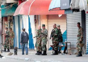 Syrian military forces line the streets after dispersing protesters in Daraa