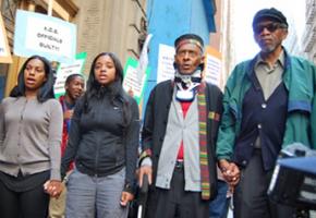 Rev. Herbert Daughtry (second from right) stands with fellow protesters to defend the day care center he founded